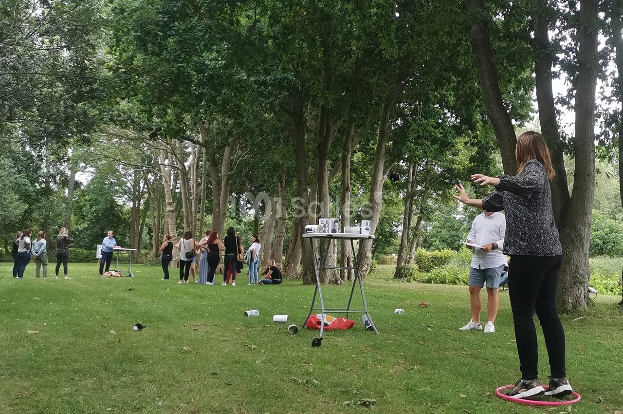 Des personnes participent à une activité en plein air dans un parc, avec des jeux et des interactions en groupe.