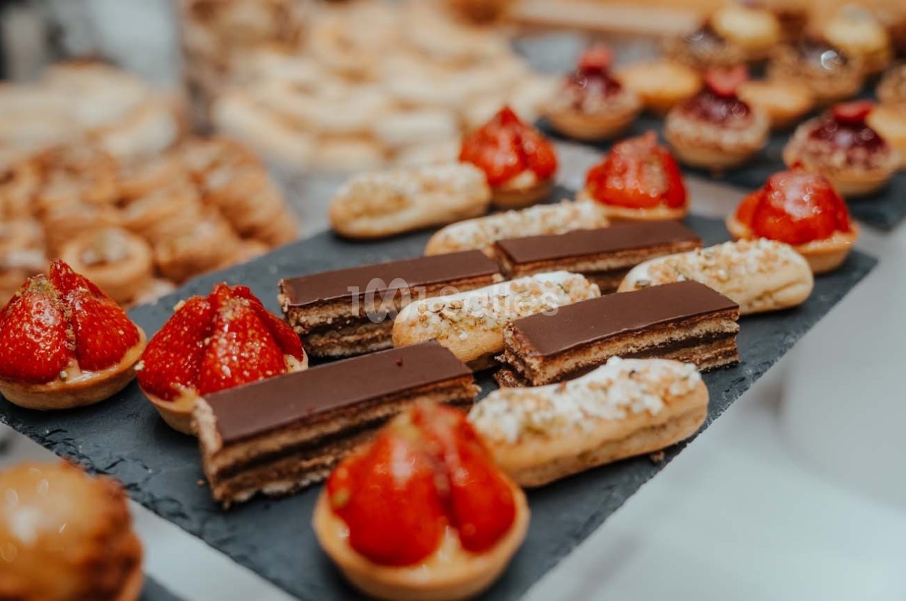 Plateau de pâtisseries variées comprenant éclairs au chocolat, tartelettes aux fraises et autres desserts.