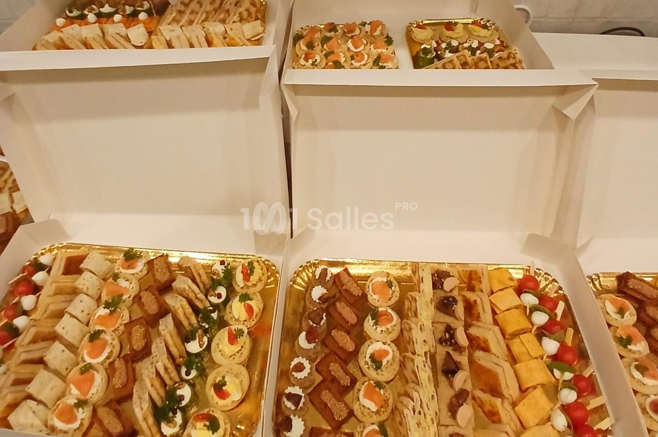 Plateaux garnis d'amuse-bouches variés, incluant canapés, mini-sandwichs, roulés et bouchées apéritives.