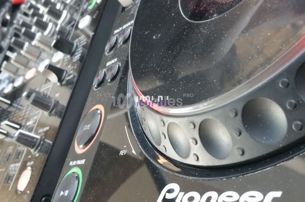 Table de mixage avec des boutons de contrôle et un lecteur CD de marque Pioneer en gros plan.