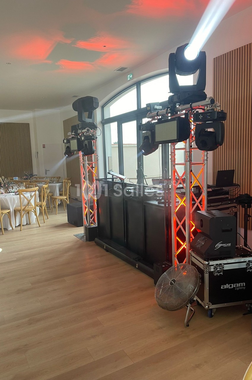 Installation de matériel de sonorisation et d'éclairage avec projecteurs et enceintes dans une salle de réception.