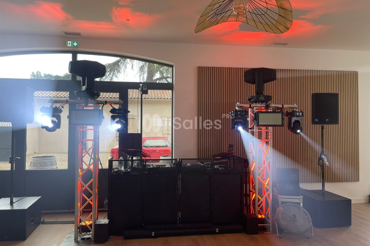 Installation de matériel de sonorisation et d'éclairage avec projecteurs et enceintes dans une salle lumineuse.