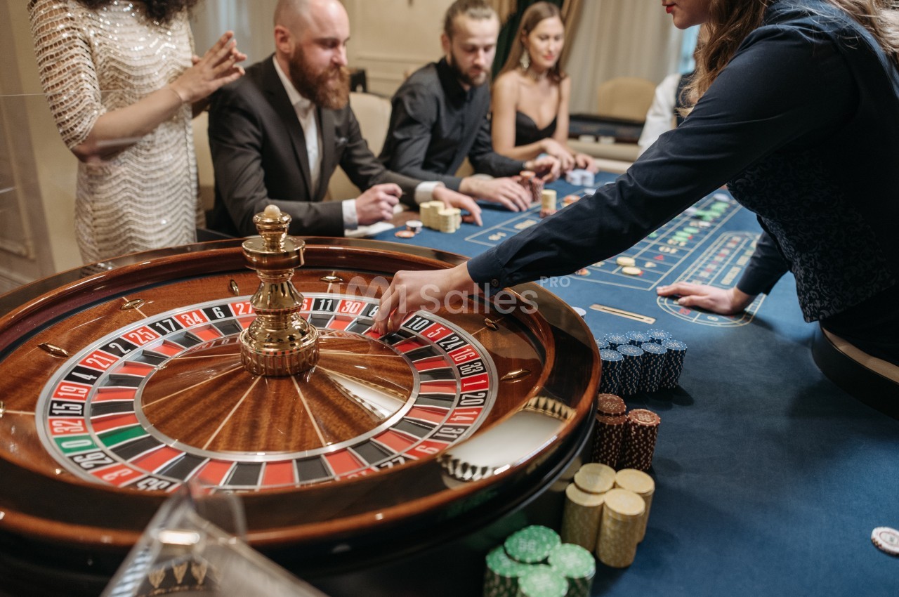 Personnes jouant à la roulette dans un casino, avec des jetons posés sur la table de jeu.