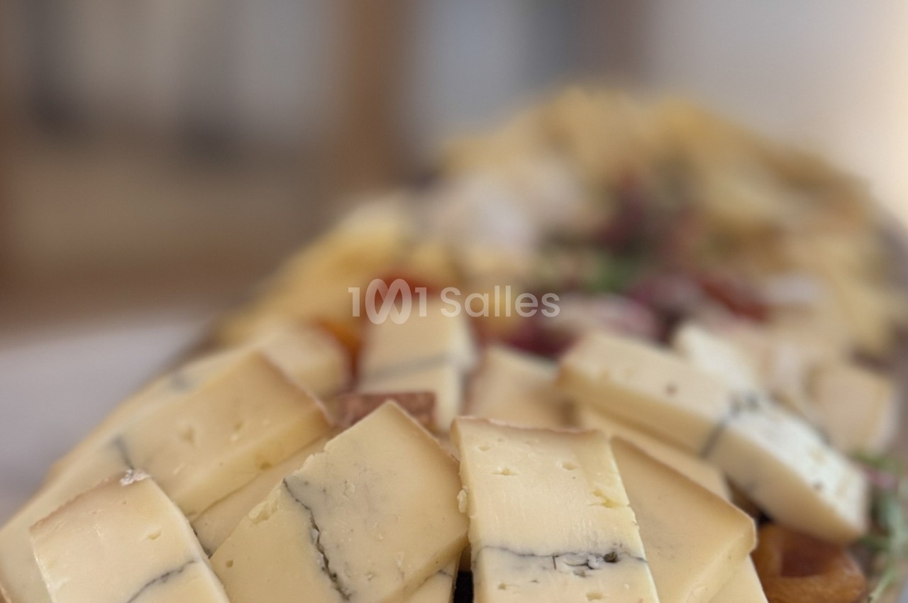 Plateau de fromages variés avec des morceaux de fromage à pâte dure et persillée, disposés sur une planche en bois.