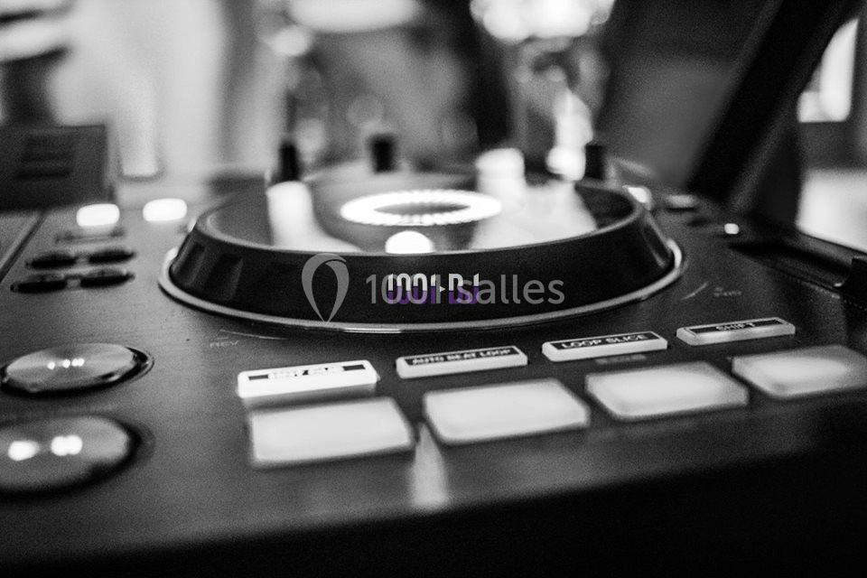 Table de mixage en gros plan avec des boutons et un plateau tournant, en noir et blanc.