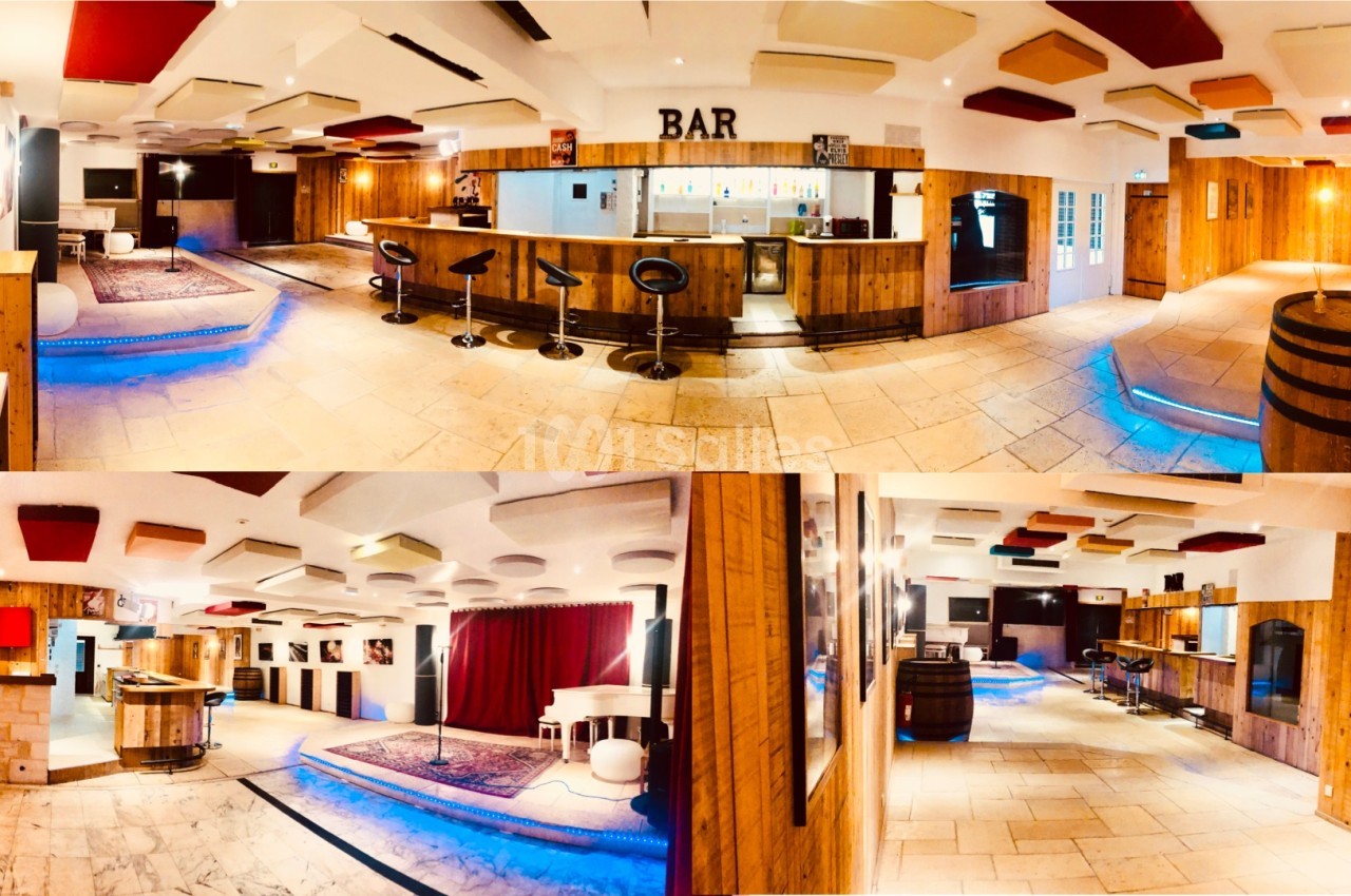 Salle lumineuse avec bar en bois, éclairages bleus au sol, plafond acoustique et espace avec piano blanc.