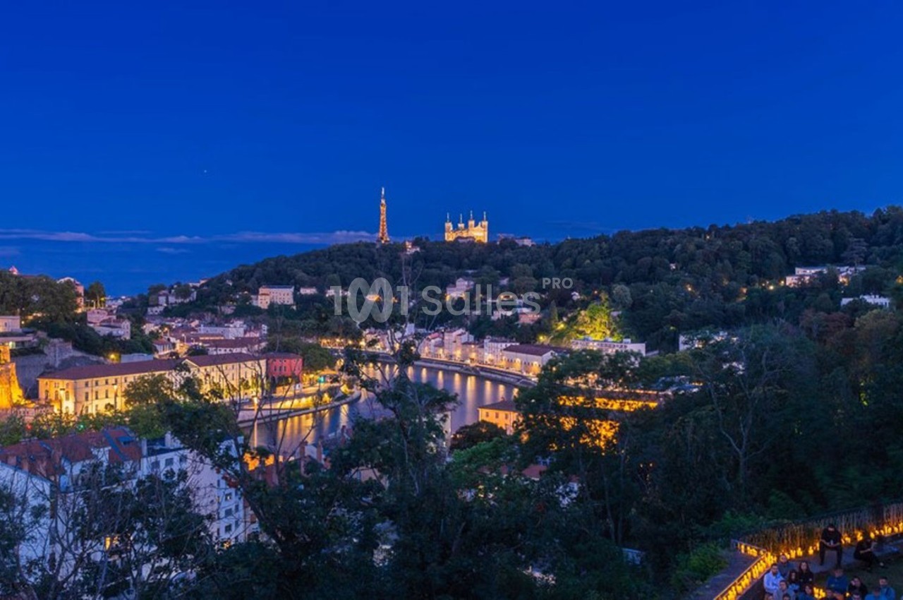 Vue nocturne de Lyon avec la colline de Fourvière illuminée et la Saône traversant la ville.