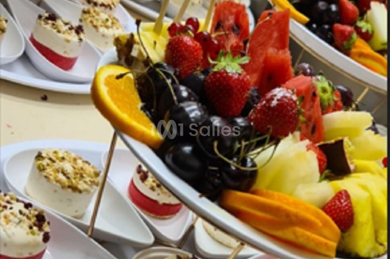 Plateaux garnis de fruits frais variés, tels que fraises, cerises, pastèque et tranches d'orange, accompagnés de desserts.