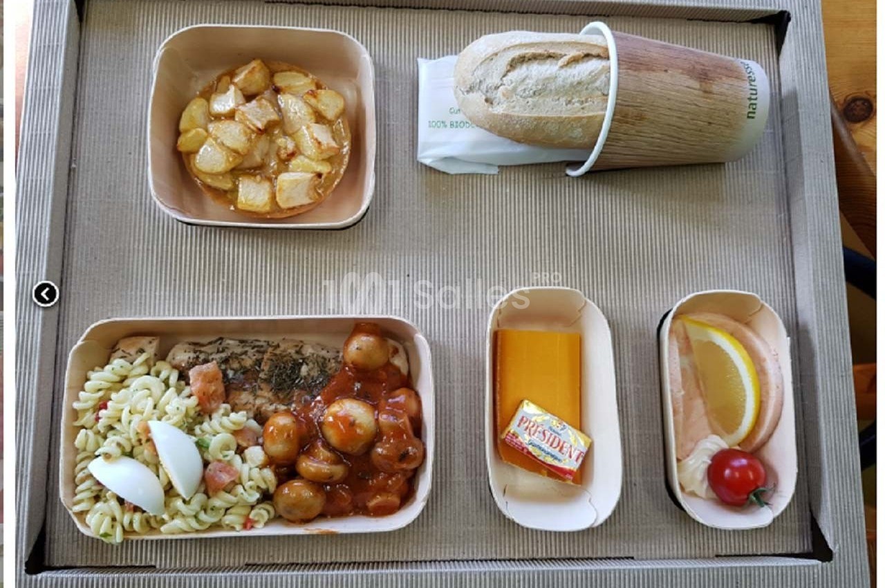 Plateau-repas avec pâtes, viande en sauce, pommes de terre, fromage, dessert, pain et beurre.