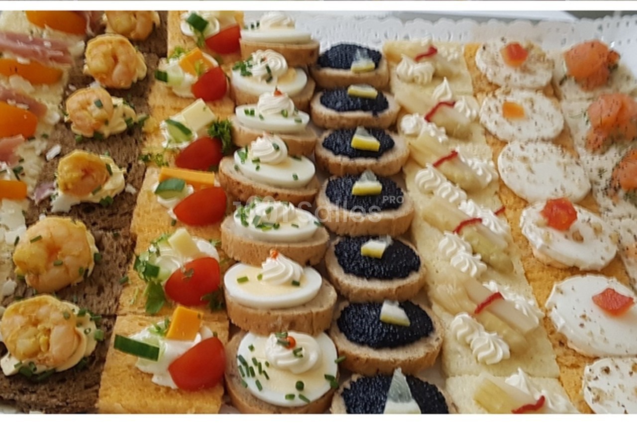 Plateau de canapés variés avec garnitures colorées, incluant crevettes, fromage, légumes, œufs de poisson et herbes.