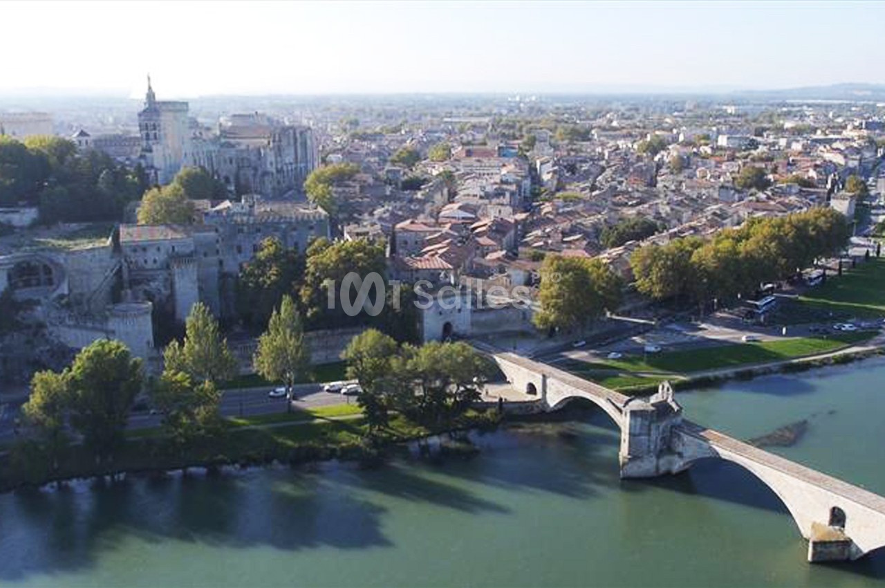 Vue aérienne d'Avignon avec le pont Saint-Bénézet, le Rhône et le Palais des Papes en arrière-plan.