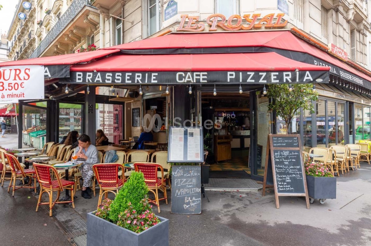 Façade d'une brasserie avec terrasse, tables occupées, menus affichés et enseigne ’Le Royal’ visible.