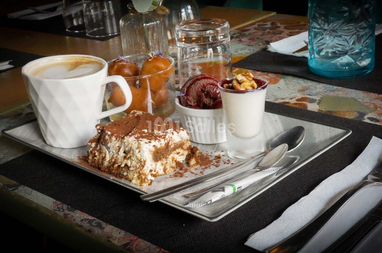Plateau de desserts variés avec tiramisu, verrines, café et beignets, présenté sur une table dressée.