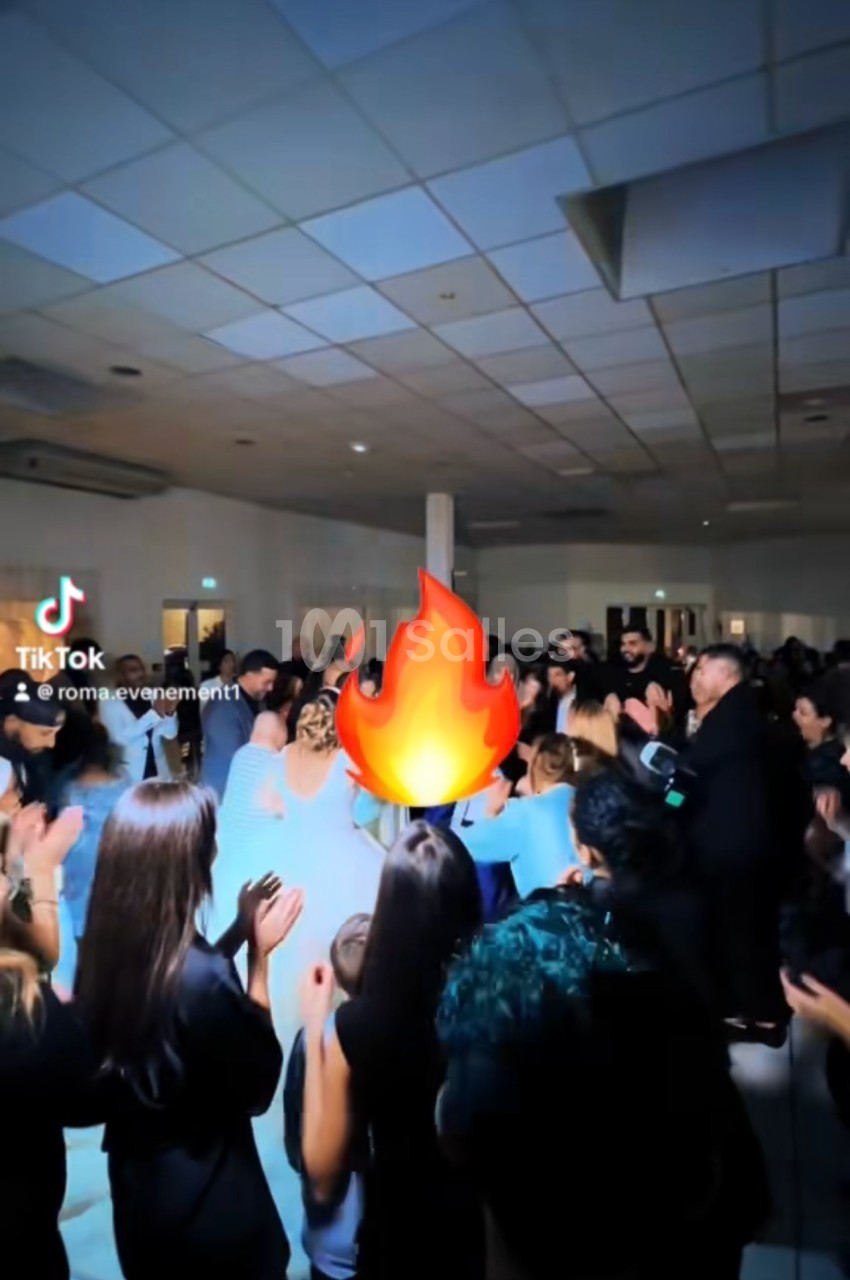 Un groupe de personnes dans une salle éclairée, applaudissant autour d'une animation de flamme ajoutée numériquement.
