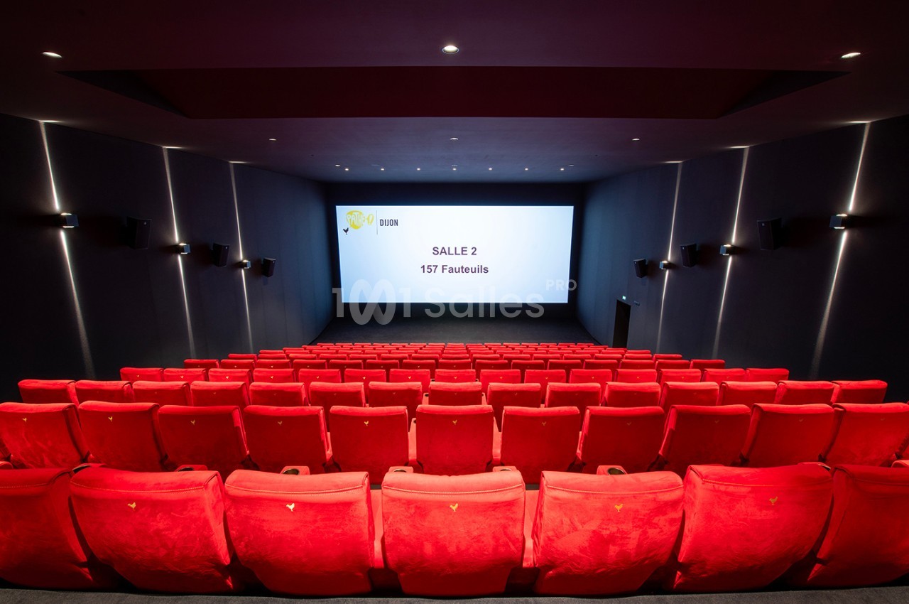 Salle de cinéma vide avec des rangées de fauteuils rouges et un écran affichant ’Salle 2 - 157 Fauteuils’.
