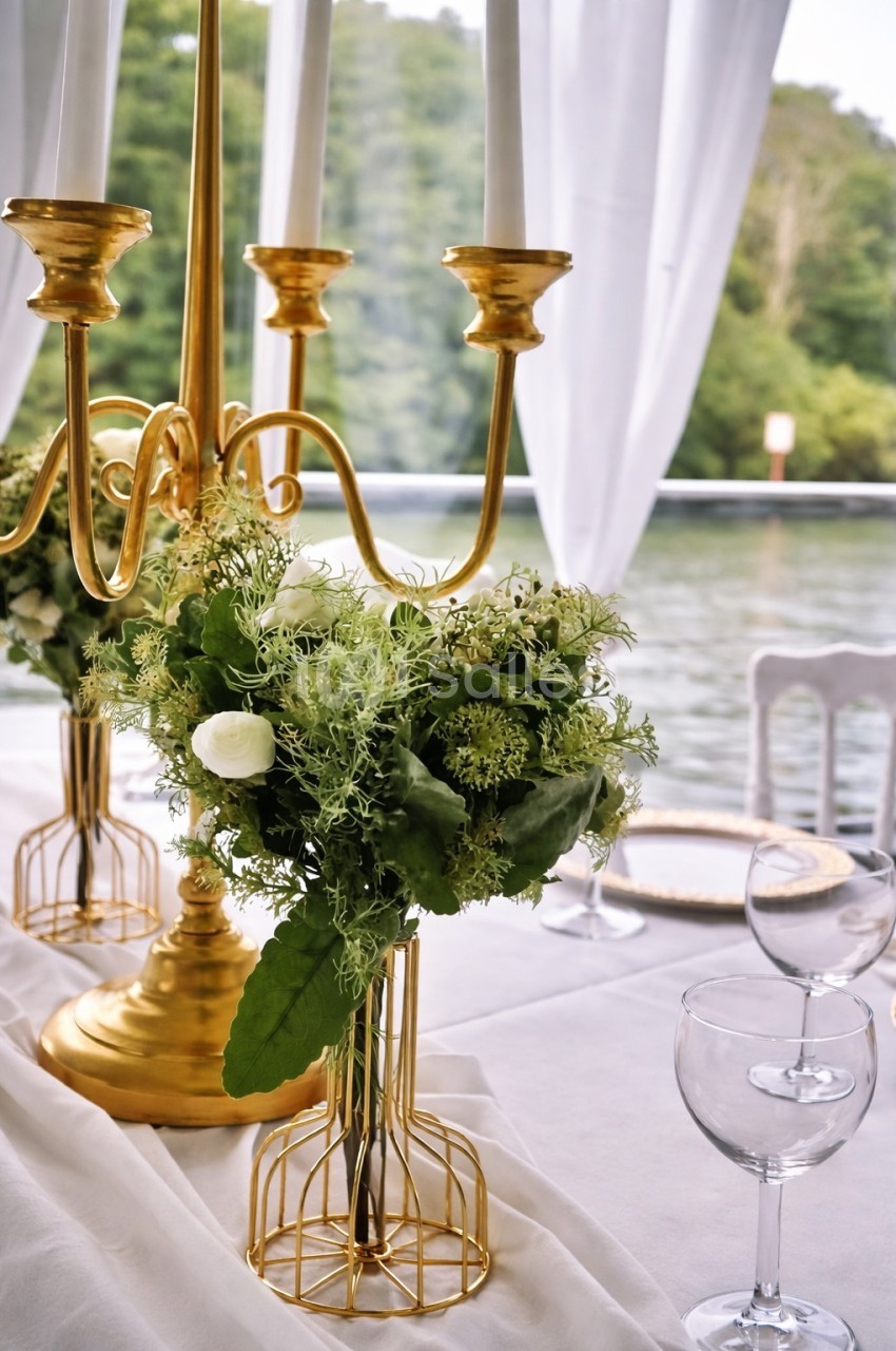 Bouquet de fleurs vertes et blanches sur une table décorée avec un chandelier doré, près d'une fenêtre donnant sur un…