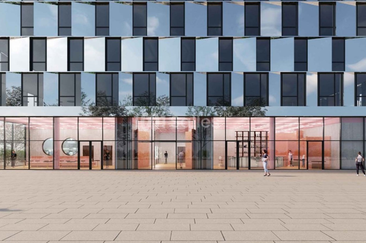 Façade moderne d'un bâtiment avec de grandes baies vitrées, reflétant le ciel et entourée d'une place pavée.