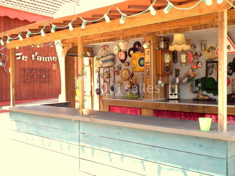 Stand en bois décoré d'objets vintage et lumineux, avec une guirlande suspendue et une inscription ’Je t'aime’ en arrière…
