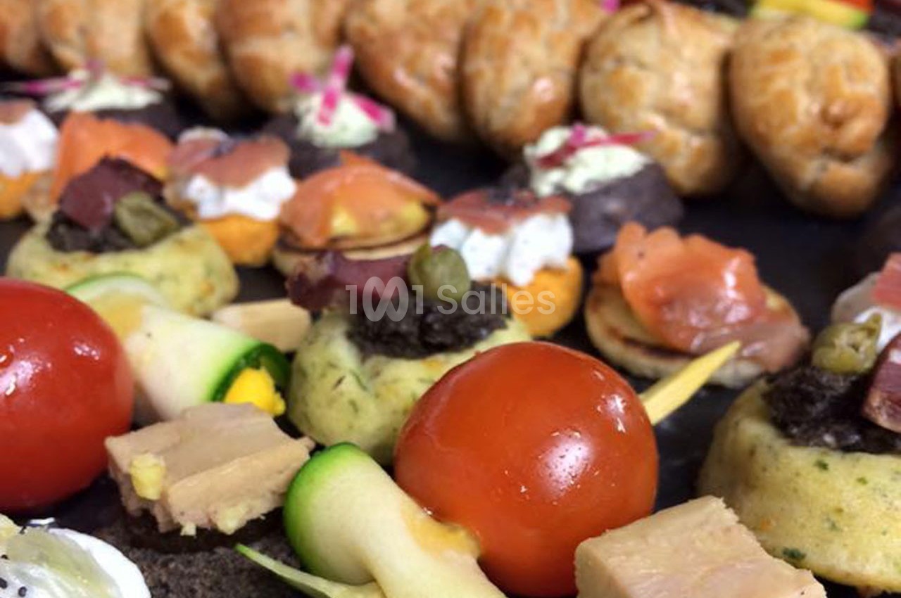 Plateau de bouchées apéritives variées comprenant légumes, foie gras, saumon fumé et feuilletés.