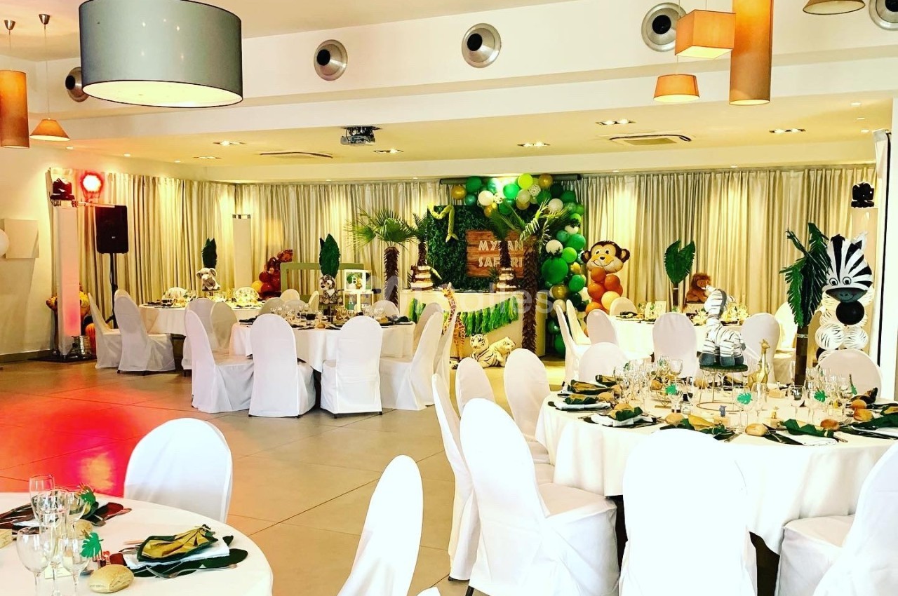 Salle de réception décorée sur le thème de la jungle avec des tables dressées et des éléments décoratifs exotiques.