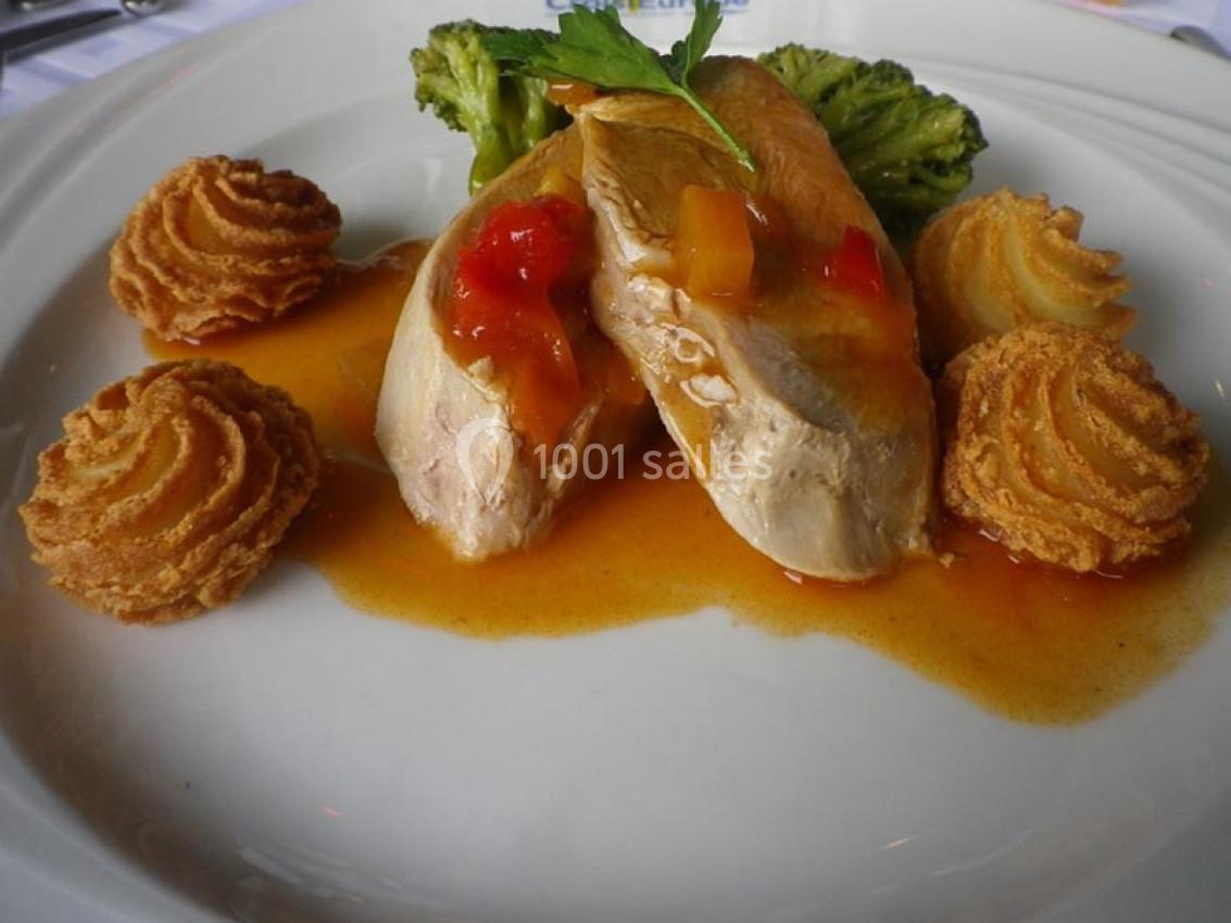 Assiette de volaille nappée de sauce, accompagnée de brocolis et de pommes duchesse dorées.