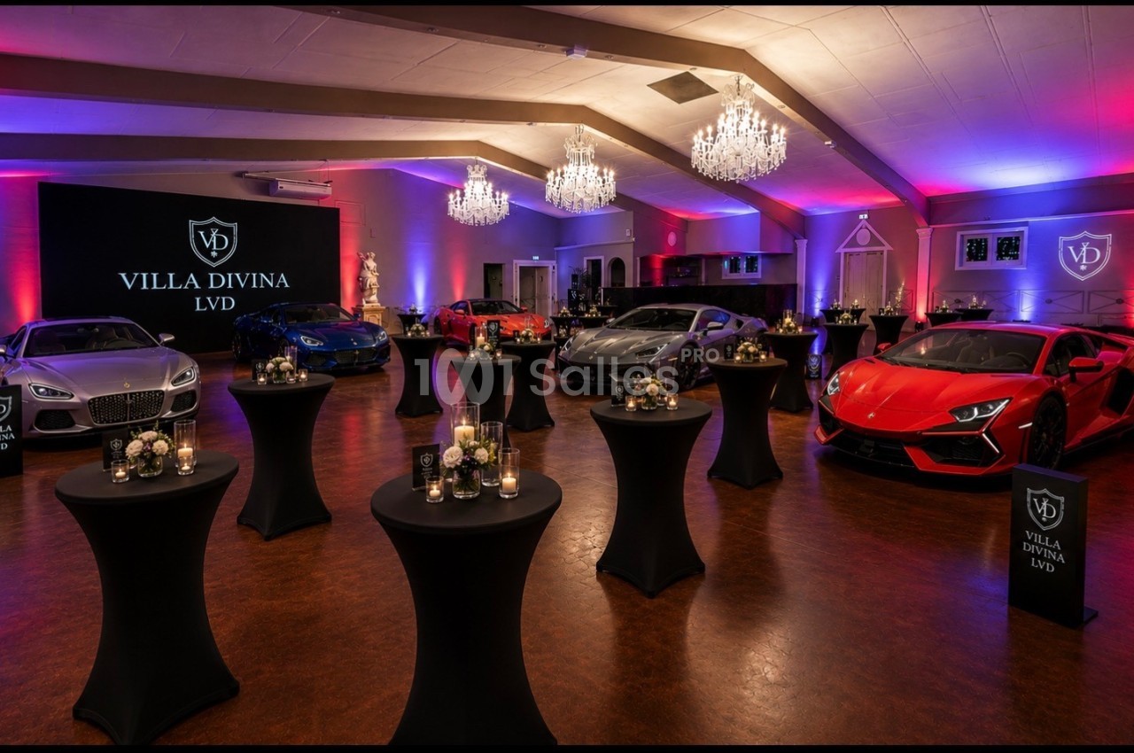Salle élégante avec voitures de luxe exposées, éclairage coloré et tables hautes décorées de bougies et fleurs.