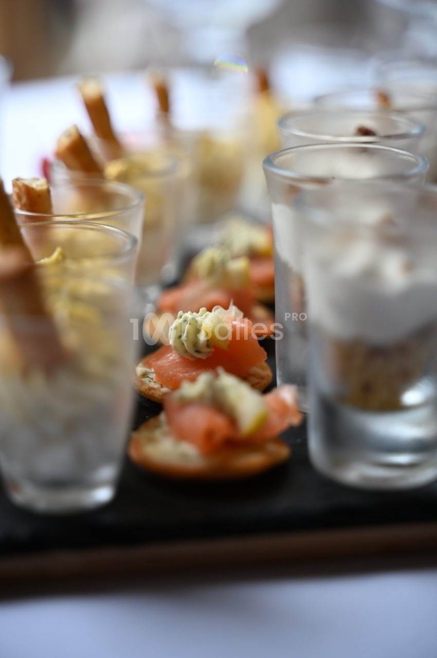Plateau de verrines et amuse-bouches variés, disposés sur une ardoise pour un service élégant.