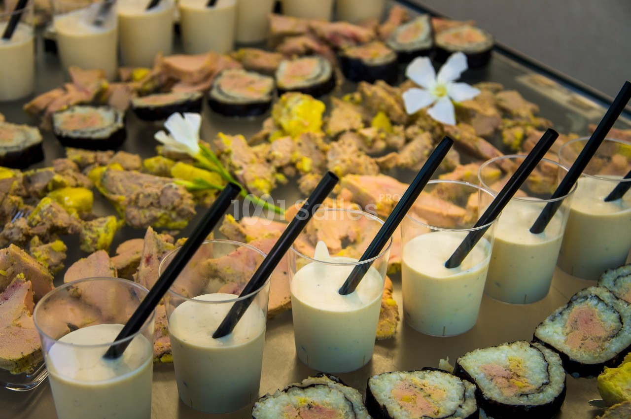 Plateau de verrines, sushis et toasts garnis, disposés sur une table pour un buffet ou un apéritif.