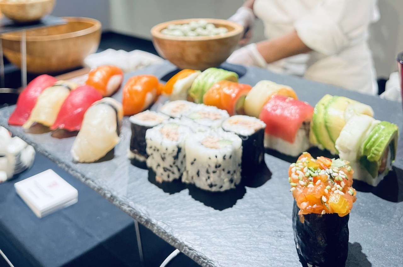 Plateau de sushis variés comprenant nigiris, makis et gunkan, présenté sur une ardoise noire.
