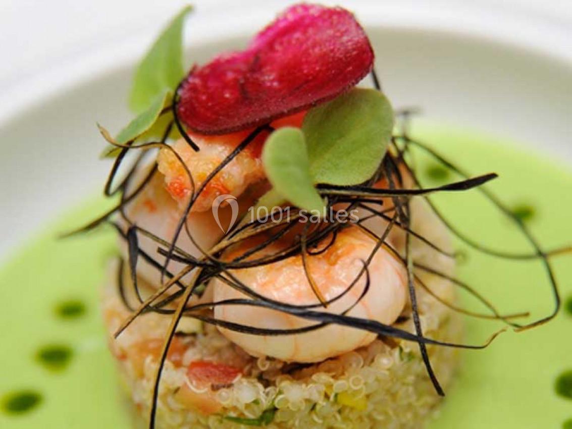 Plat gastronomique composé de crevettes, quinoa, herbes fraîches, chips de betterave et sauce verte.