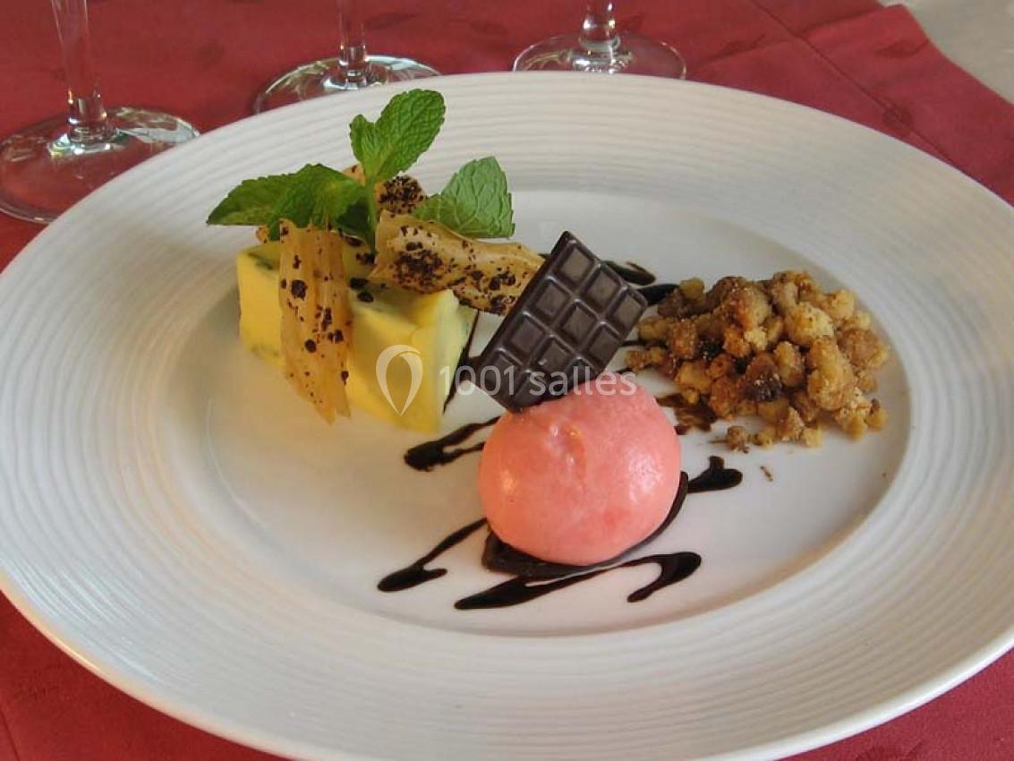 Assiette de dessert composée de mousse, sorbet rose, crumble, chocolat et décorée de menthe et sauce chocolat.