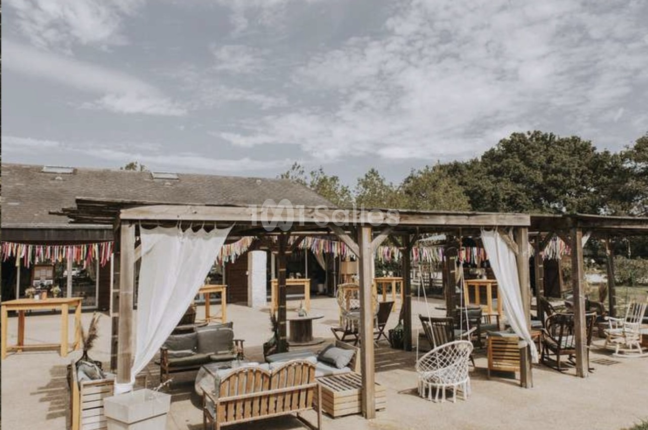 Terrasse extérieure avec pergolas en bois, mobilier de jardin varié et ciel partiellement nuageux en arrière-plan.
