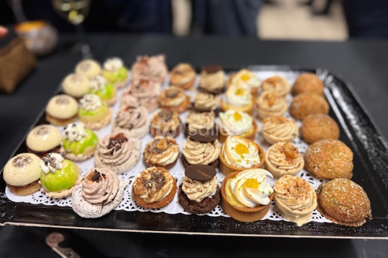 Plateau de mignardises variées disposées sur une nappe noire, comprenant des desserts sucrés et colorés.