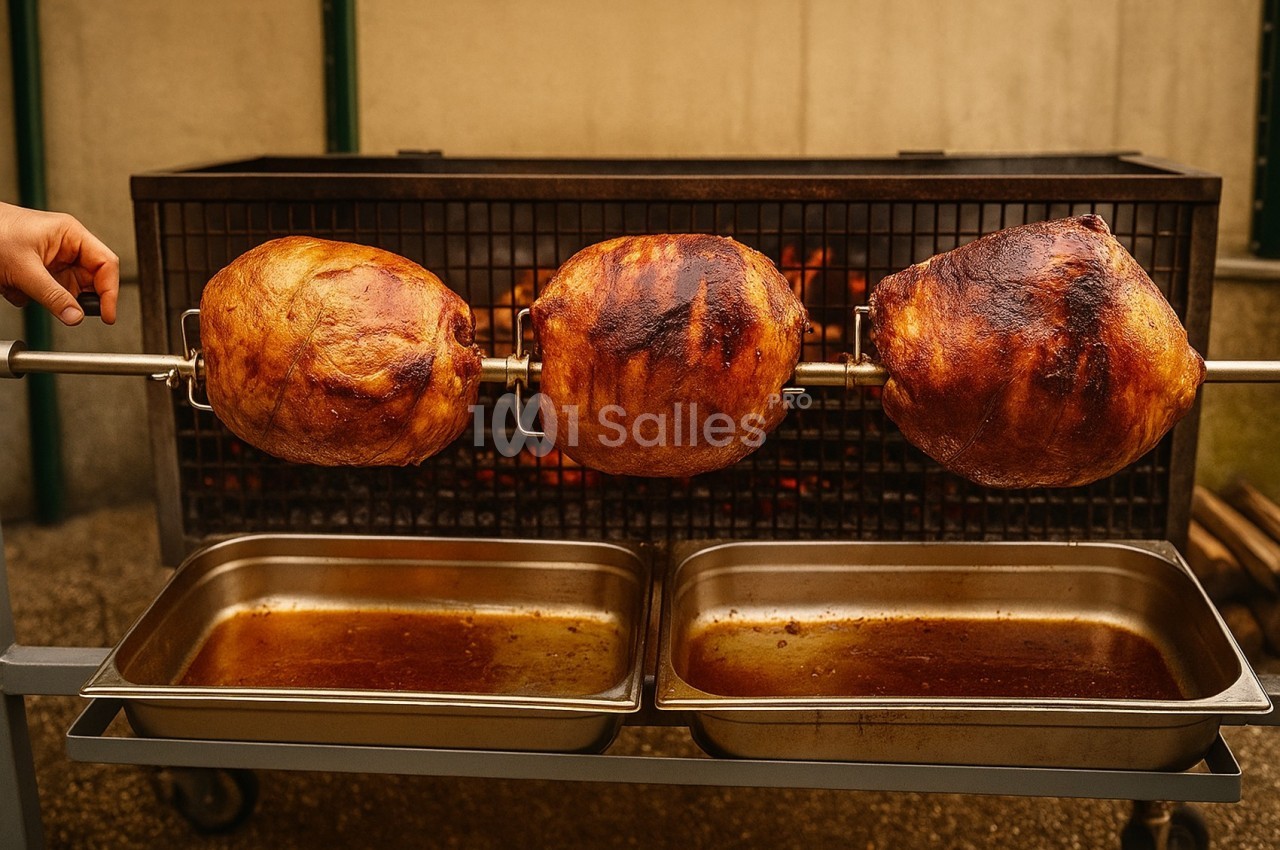 Trois morceaux de viande rôtissant sur une broche devant un feu, avec des bacs en dessous pour recueillir les jus.