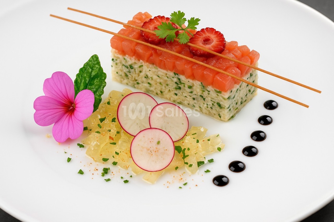 Plat gastronomique composé de tartare de saumon, radis, gelée, fleur comestible et sauce balsamique décorative.