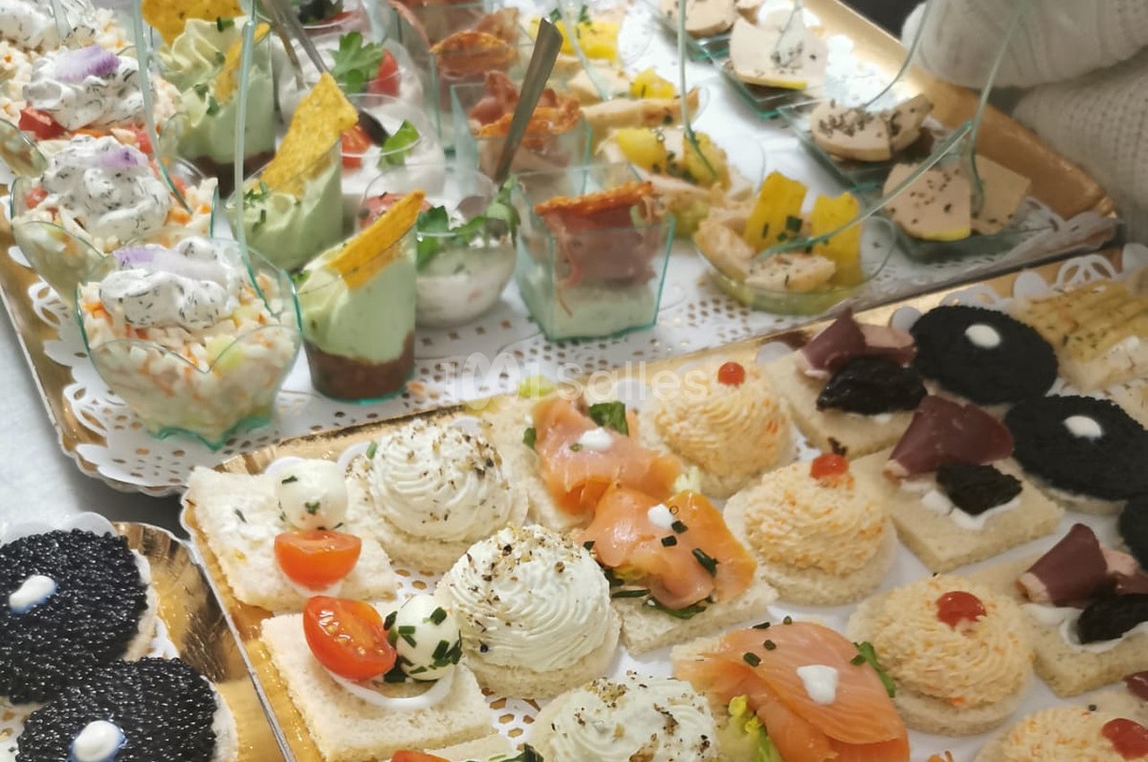 Plateau de bouchées apéritives variées avec saumon, caviar, verrines et autres garnitures colorées.