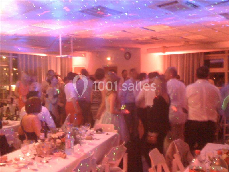 Groupe de personnes dans une salle éclairée de lumières colorées, lors d'une fête ou d'un événement festif.