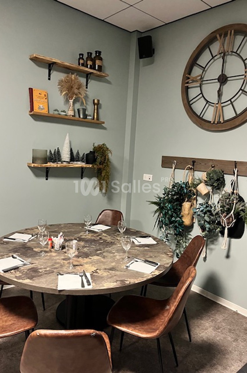 Salle à manger décorée avec une table ronde, des chaises en cuir, des étagères murales et une grande horloge.