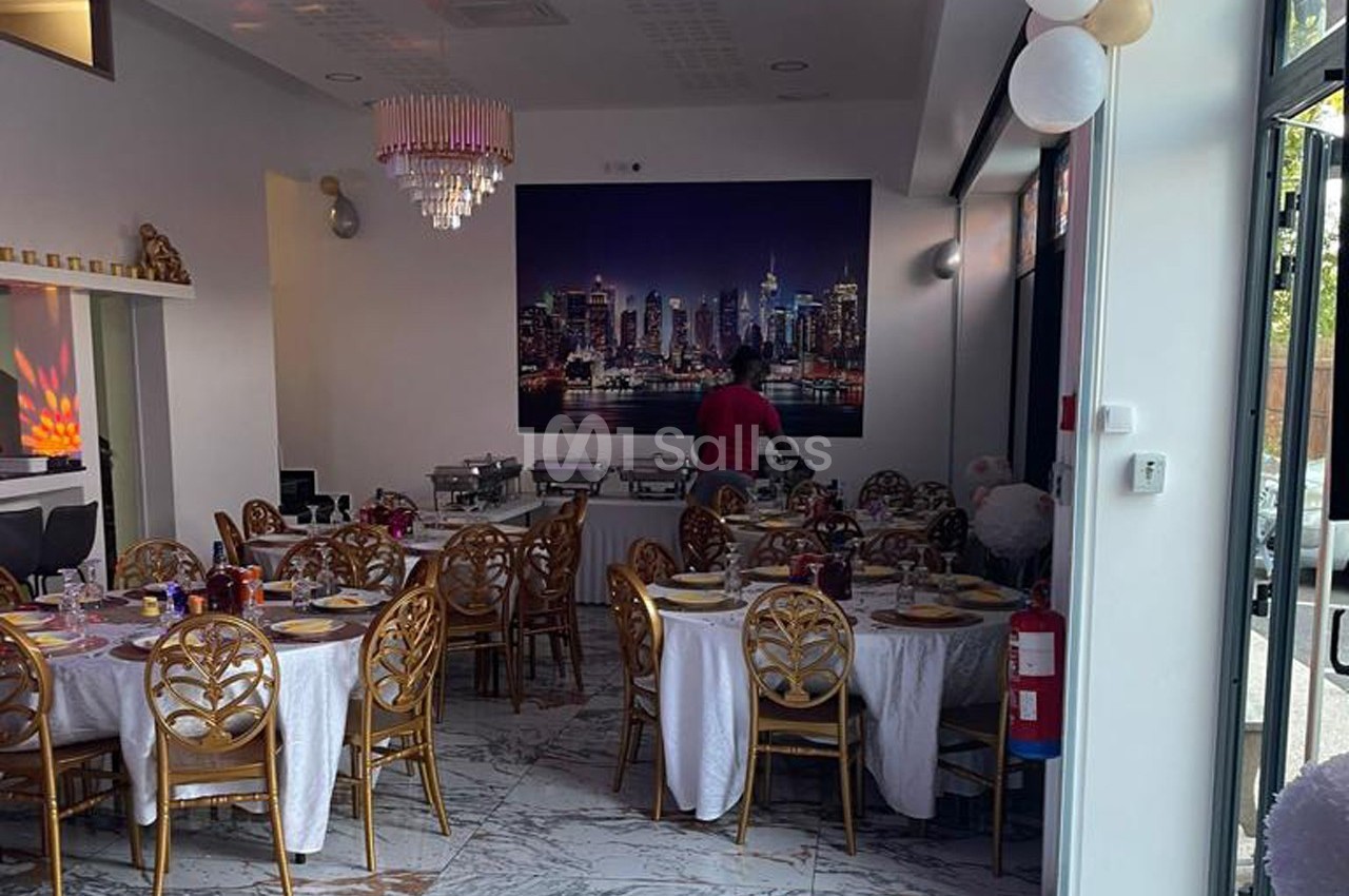 Salle de réception décorée avec des tables rondes dressées, un buffet en arrière-plan et un mur orné d'une photo de skyline.