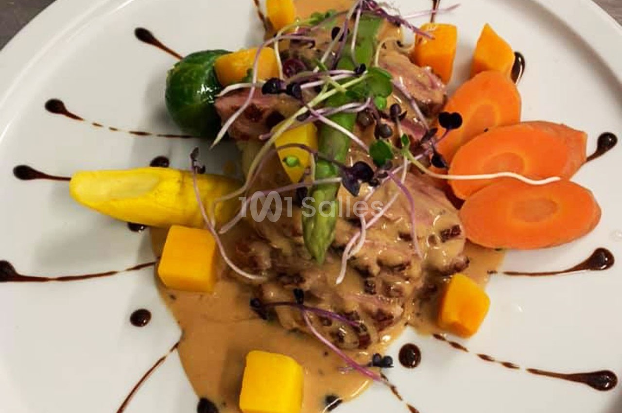 Assiette gastronomique avec viande en sauce, légumes colorés, asperge, germes et filet de réduction balsamique.