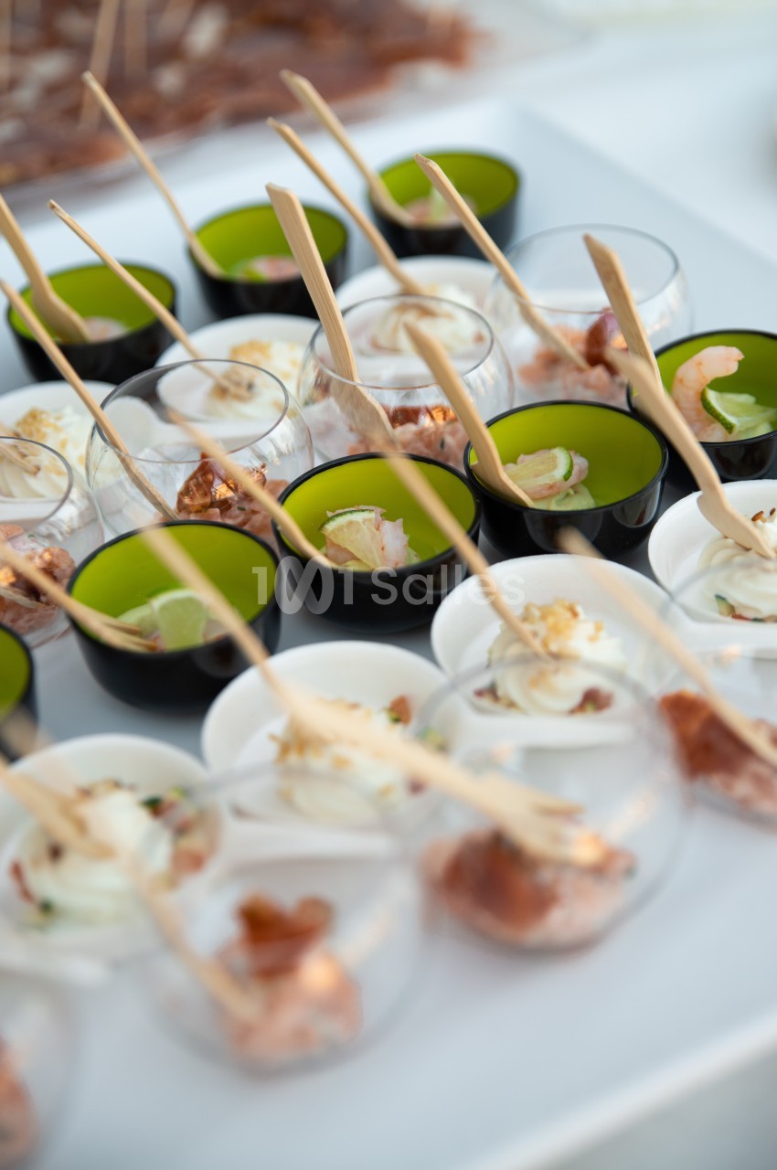 Assortiment de verrines colorées contenant des entrées variées, présentées avec des cuillères en bois.