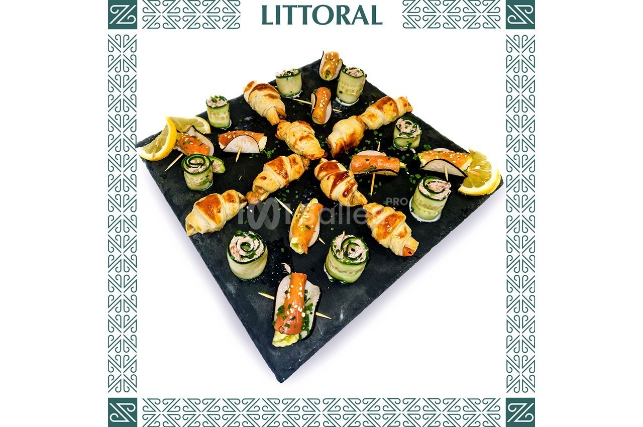 Plateau d'amuse-bouches variés comprenant croissants, roulés de légumes et saumon, décoré de citron et herbes.