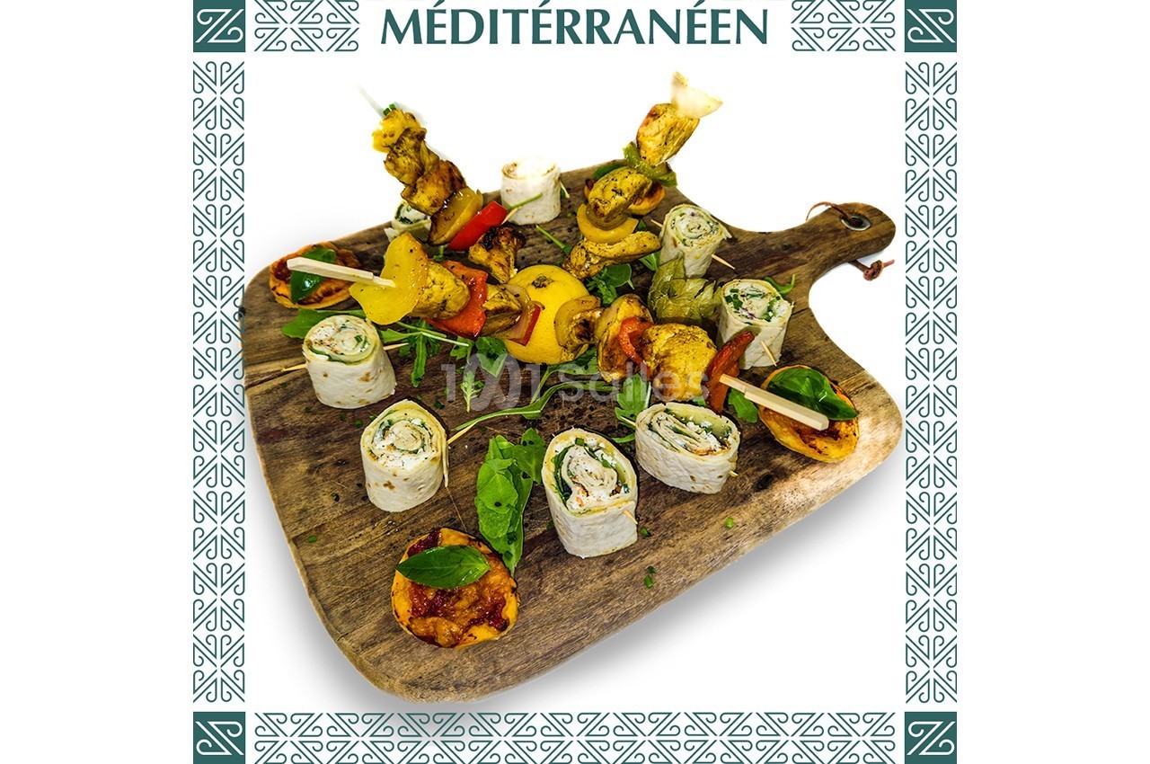 Plateau en bois garni de brochettes, roulés garnis, légumes grillés et herbes fraîches, style méditerranéen.