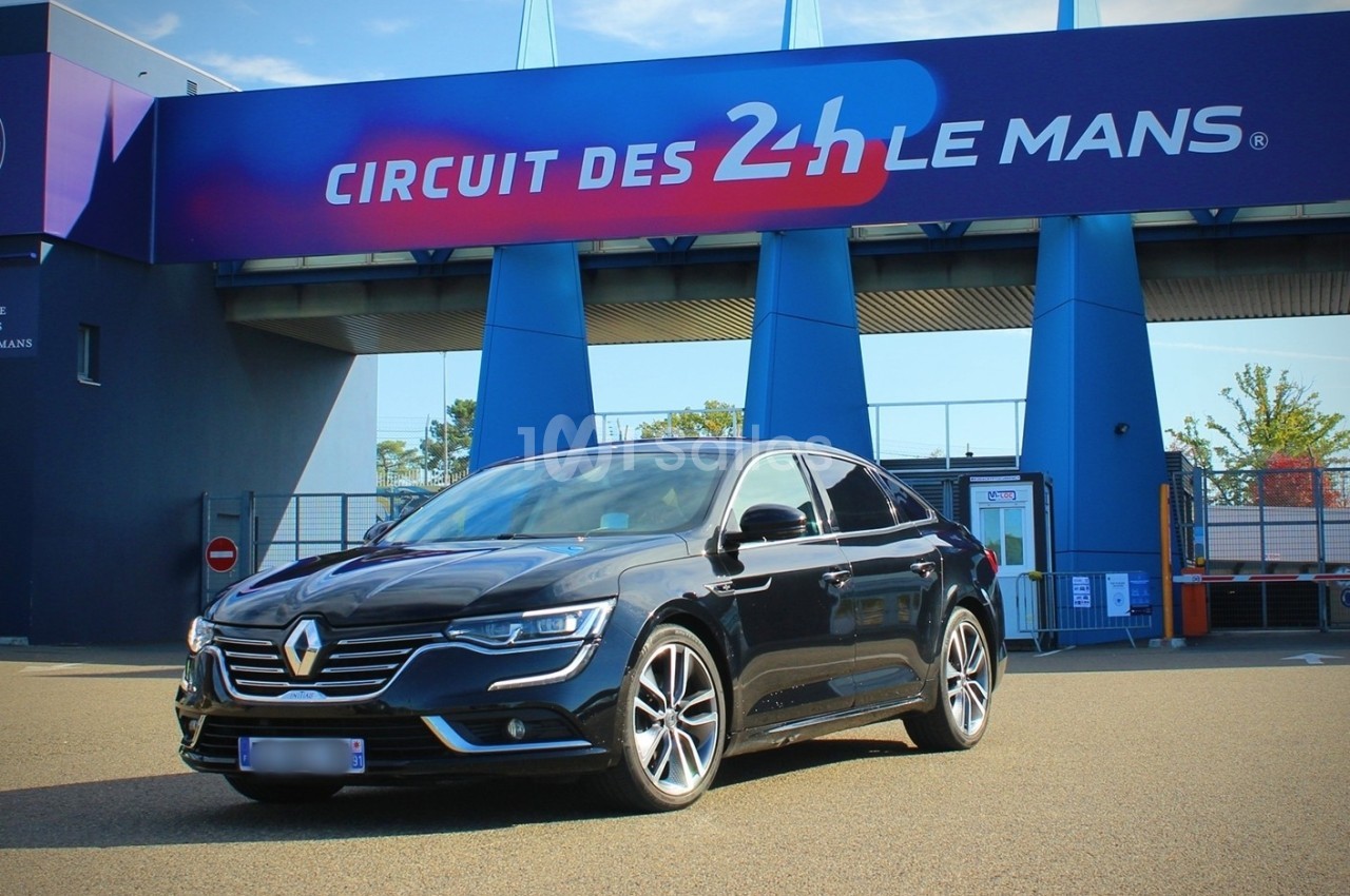 Voiture Renault noire stationnée devant l'entrée du circuit des 24 Heures du Mans.