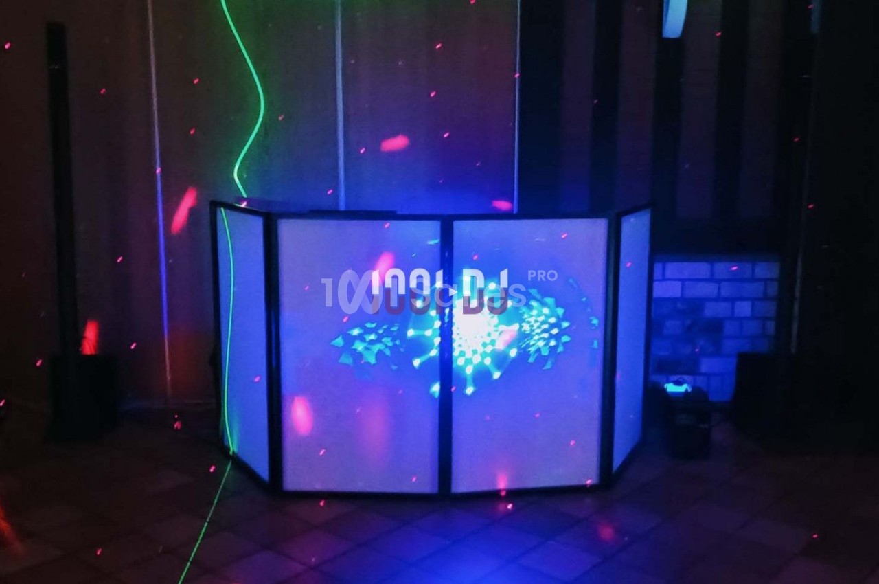 Pupitre de DJ éclairé avec des lumières colorées et des lasers dans une pièce sombre.