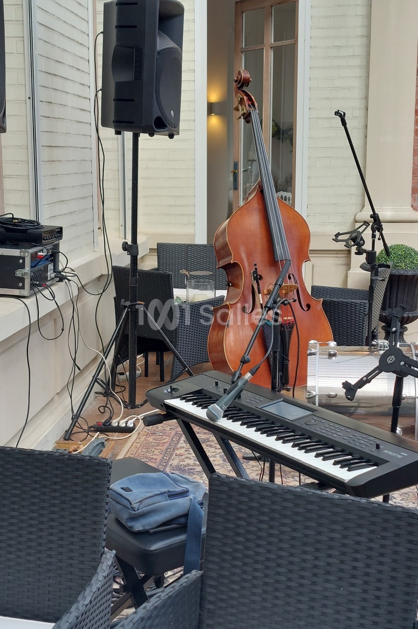 Instruments de musique installés en extérieur avec un clavier, une contrebasse, des micros et des enceintes.