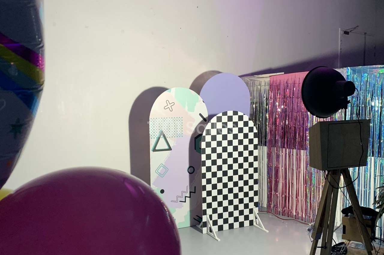 Décor coloré avec panneaux géométriques et rideaux brillants dans un studio éclairé.