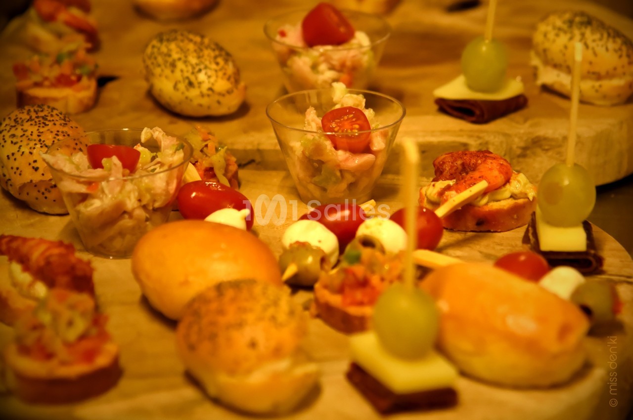 Assortiment de bouchées apéritives variées disposées sur un plateau en bois.