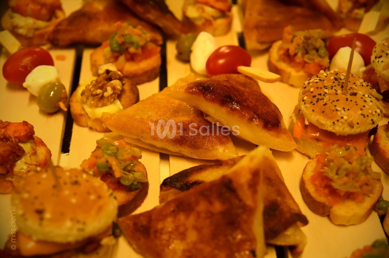 Assortiment de bouchées apéritives variées, incluant mini-burgers, feuilletés et canapés garnis.