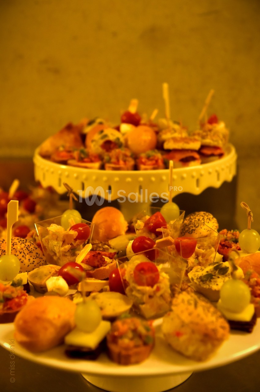 Plateaux de bouchées apéritives variées avec légumes, fromage et pain, présentées sur des supports décoratifs.